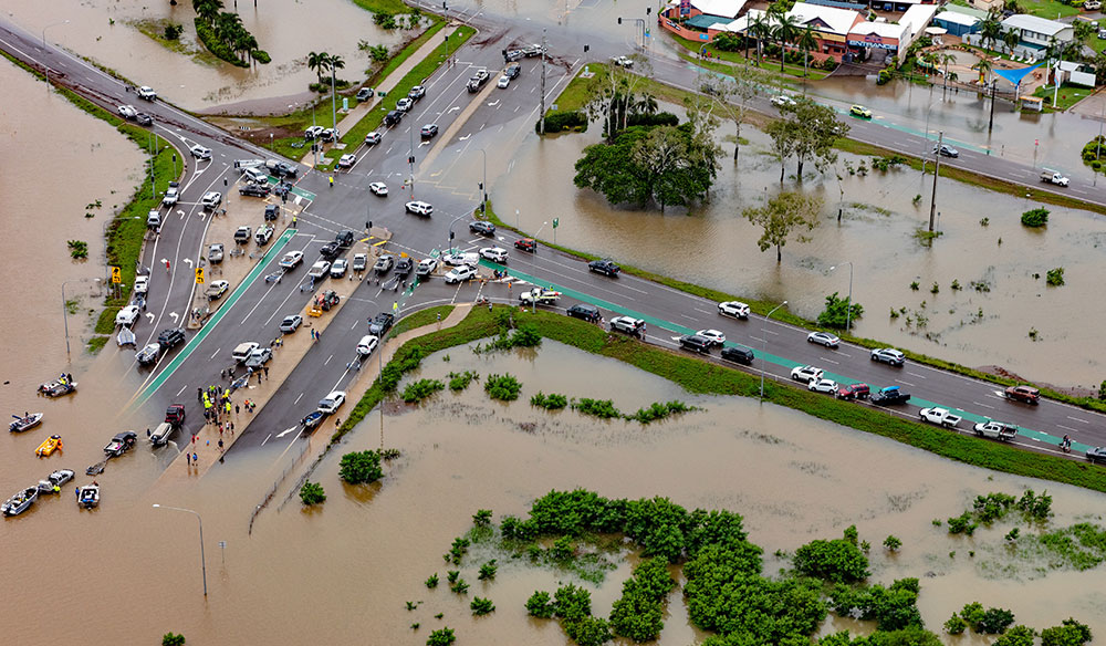 Drone veiew of flooded roads and land near an intersection.